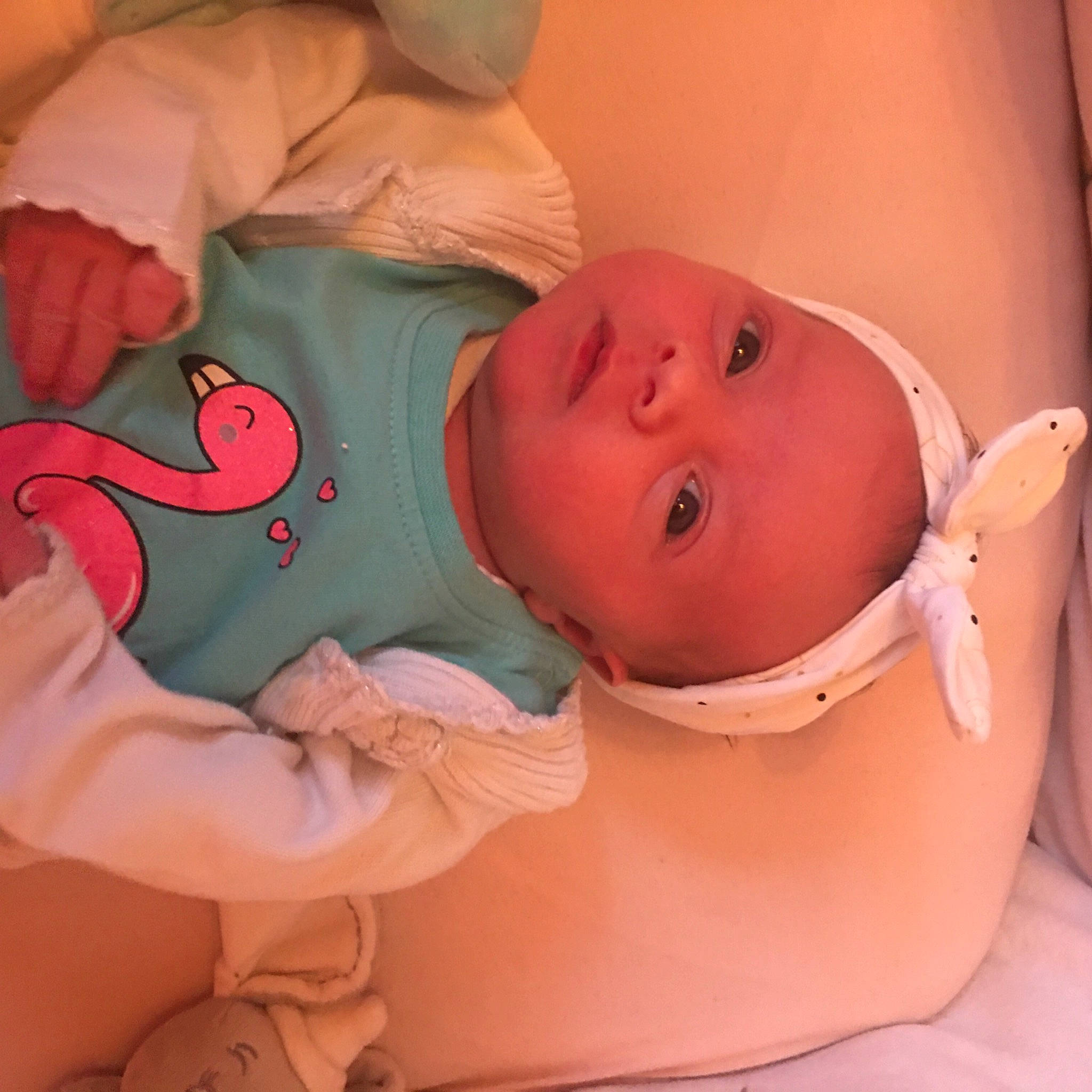 Capucine participe au concours pour gagner de l'argent avec cette photo : arm, baby, baby_safety, baby_toddler_clothing, bed, cheek, comfort, eye, finger, human_body, iris, lip, mouth, neck, nose, orange, person, product, skin, sleeve