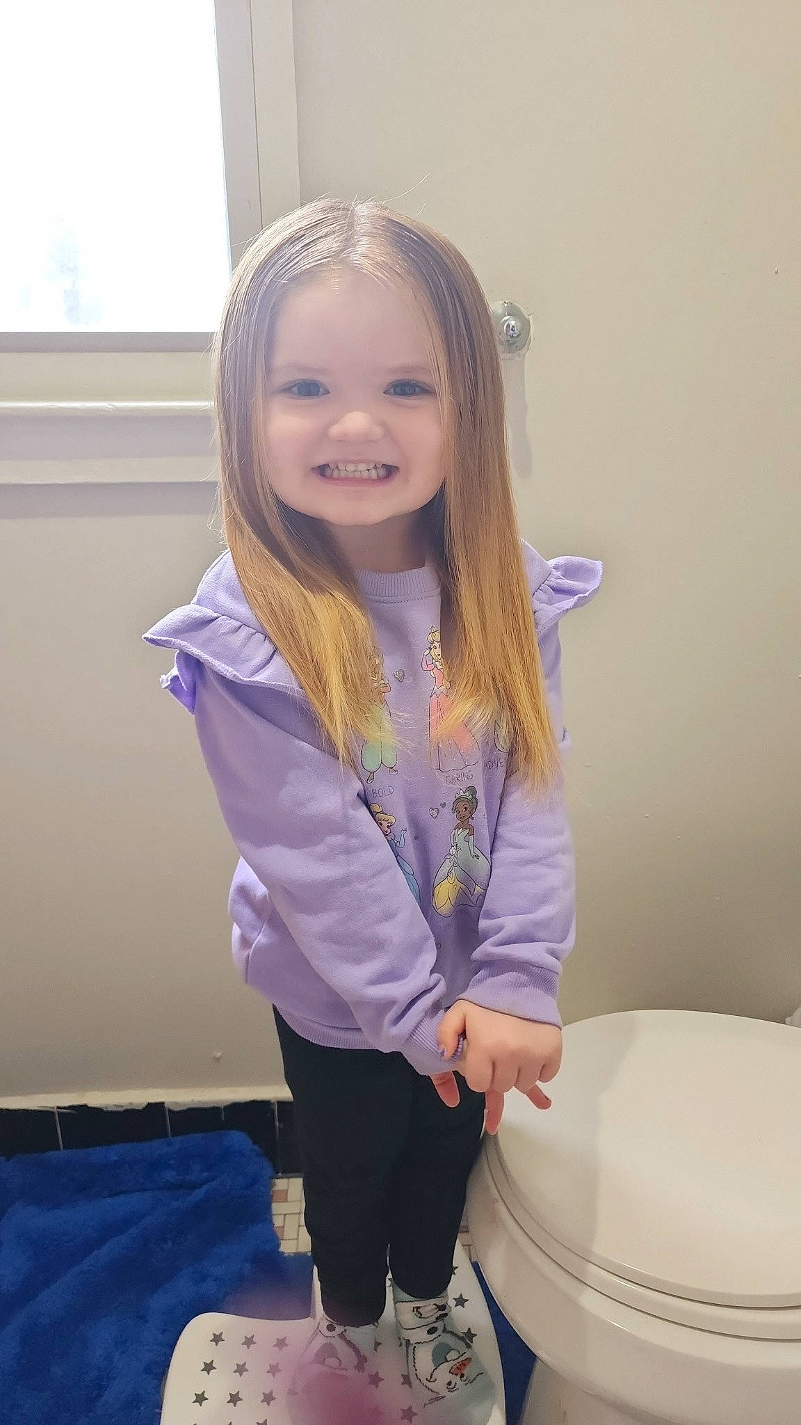 Ryleigh is registered to the contest to win money with this photo: blond, child, electric_blue, face, fun, hair, happy, head, human_leg, joy, long_hair, person, purple, room, sitting, sleeve, smile, sportswear, t_shirt, toddler