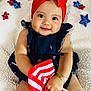 baby, child, smile, red_bow, headband, flag, american_flag, bracelet, blue_dress, stars, sparkly, blanket, happy, cute, portrait, indoors, celebration, holiday, festive, person