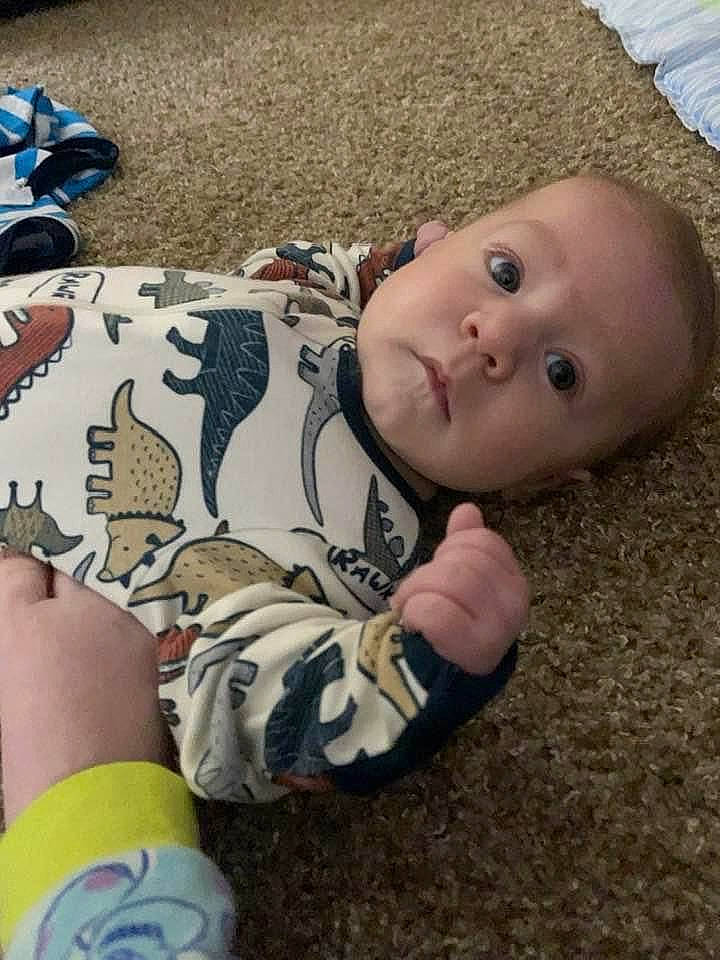 Beckett is registered to the contest to win money with this photo: baby, baby_toddler_clothing, cheek, child, cool, finger, flooring, fun, grass, hairstyle, human, mammal, pattern, person, sitting, skin, sleeve, t_shirt, toddler, vertebrate