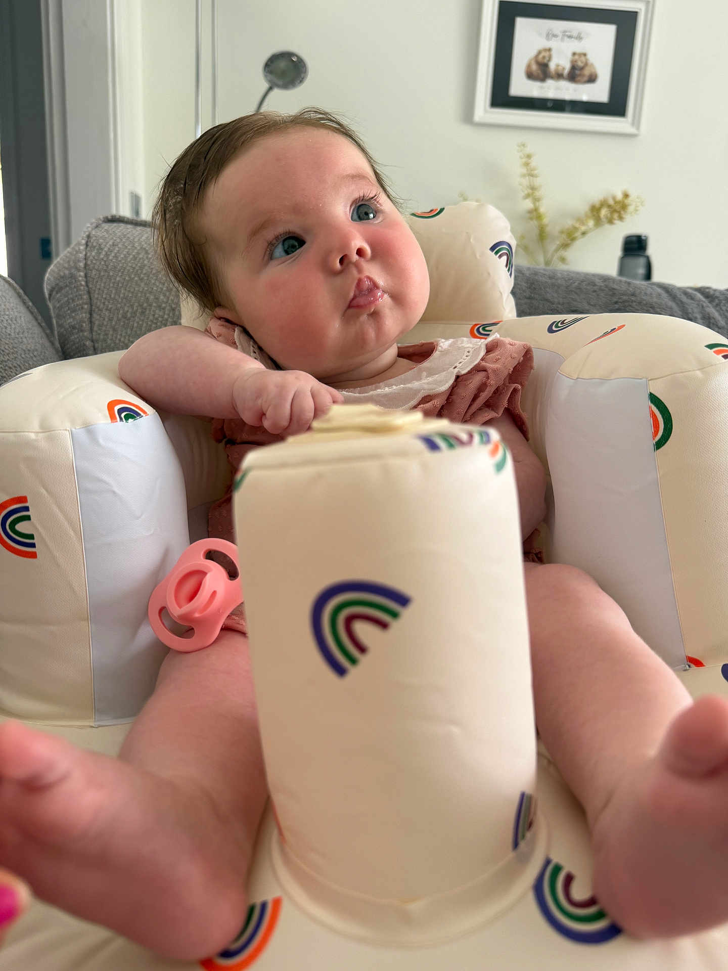 Lottie joined the competition — help win amazing prizes! baby, infant, child, seat, pacifier, rainbow_pattern, couch, living_room, blue_eyes, pink, plush, comfortable, cute, portrait, indoors, furniture, soft_toys, curious, skin, clothing