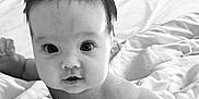 Lottie joined the competition — help win amazing prizes! baby, infant, face, close_up, black_and_white, bed, blanket, skin, eyes, mouth, hand, fist, curious, cute, child, person, portrait, young, expression, lying_down