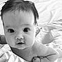baby, infant, face, close_up, black_and_white, bed, blanket, skin, eyes, mouth, hand, fist, curious, cute, child, person, portrait, young, expression, lying_down