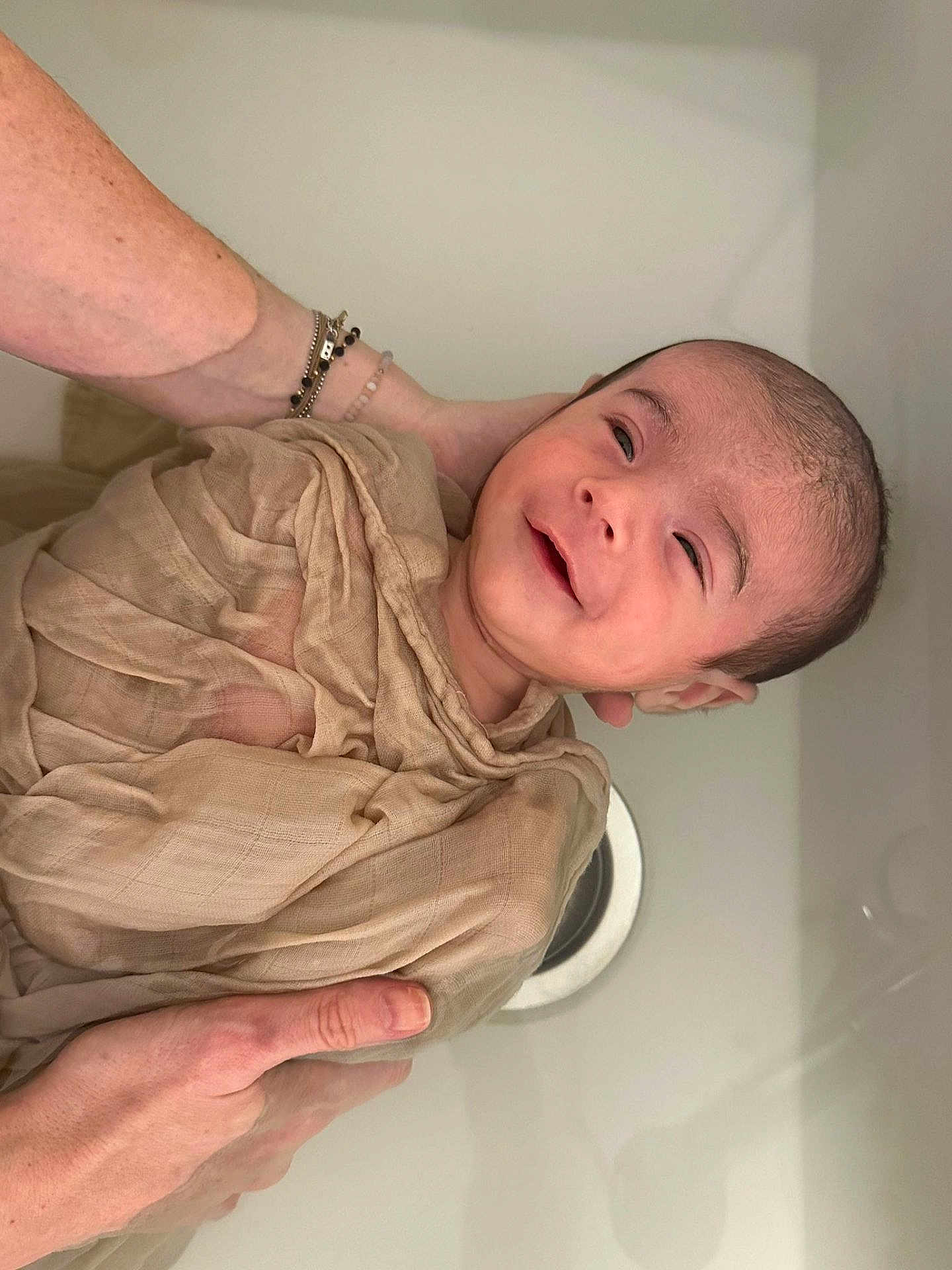 Eloan a rejoint le concours — aidez-le/la à gagner de superbes lots ! baby, child, infant, smile, hands, cloth, wrap, skin, face, head, person, newborn, holding, gentle, care, closeup, expression, happy, indoors, warm