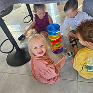 Emma participe au concours pour gagner de l'argent avec cette photo : child, toddler, indoor, playing, toy, colorful, stacking_toy, blanket_fort, floor, smiling, happy, group, friends, curly_hair, light, casual_clothing, shoes, fun, together, candid