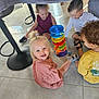 child, toddler, indoor, playing, toy, colorful, stacking_toy, blanket_fort, floor, smiling, happy, group, friends, curly_hair, light, casual_clothing, shoes, fun, together, candid