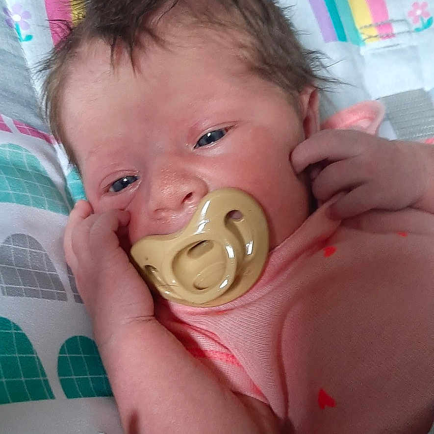 Phoenix is registered to the contest to win money with this photo: baby, pacifier, infant, child, colorful, rainbow, sun, seat, fabric, clothing, pink, cute, face, hand, newborn, soft, pattern, toy, resting, indoor