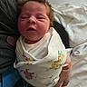 Phoenix is registered to the contest to win money with this photo: newborn, baby, swaddled, blanket, infant, human, person, sleepy, hair, cute, clothing, hand, adult, indoor, soft, portrait, closeup, resting, comfort, toddler