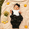 baby, black_clothing, blanket, cute, flowers, fresh, fruit, grass, greenery, headband, infant, lemons, lying_down, mesh_bag, nature, outdoor, portrait, small_flowers, summer, white_clothing
