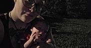 Phoenix is registered to the contest to win money with this photo: affection, baby, casual, child, closeup, dark, evening, face, family, glasses, grass, holding, human, love, night, outdoor, person, portrait, shadow, together