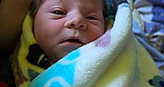 Phoenix is registered to the contest to win money with this photo: newborn, baby, blanket, wrapped, infant, face, skin, tattoo, resting, cozy, bed, fleece, colorful, soft, eyes, person, portrait, indoors, cute, young