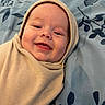 Jensen Cole is registered to the contest to win money with this photo: baby, infant, smiling, wrapped, swaddle, beige, blanket, blue, floral_pattern, face, head, happy, cute, tongue, close_up, child, portrait, soft, indoors, person