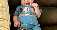 Jensen Cole joined the competition — help win amazing prizes! baby, smiling, blue_clothing, baseball_theme, couch, leather, pillow, happy, sitting, infant, cute, child, indoors, portrait, young, person, casual, relaxed, funny_face, expression