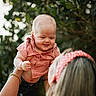 Jensen Cole is registered to the contest to win money with this photo: baby, child, person, adult, red_clothing, headband, holding, outdoor, greenery, bokeh, happy, smiling, short_sleeves, jeans, nature, portrait, family, playful, skin, head