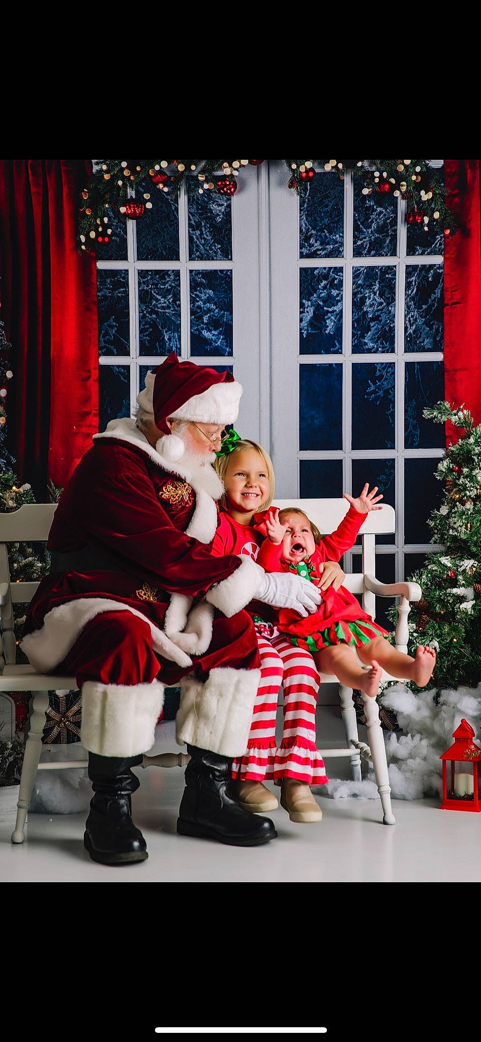Paisley is registered to the contest to win money with this photo: christmas_decoration, christmas_ornament, christmas_tree, curtain, event, fun, happy, hat, headwear, joy, lap, leg, people, person, photograph, plant, red, santa_claus, smile, snapshot