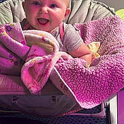 Aspen is registered to the contest to win money with this photo: baby, child, smiling, blanket, pink, cushion, chair, indoors, happy, face, clothing, person, cozy, soft, cute, infant, portrait, warm, comfort, seated