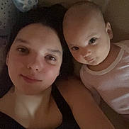 Monica participe au concours pour gagner de l'argent avec cette photo : baby, black_top, casual, child, closeup, clothing, couch, face, family, head, indoor, infant, looking_at_camera, person, portrait, relaxing, skin, together, white_onesie, woman