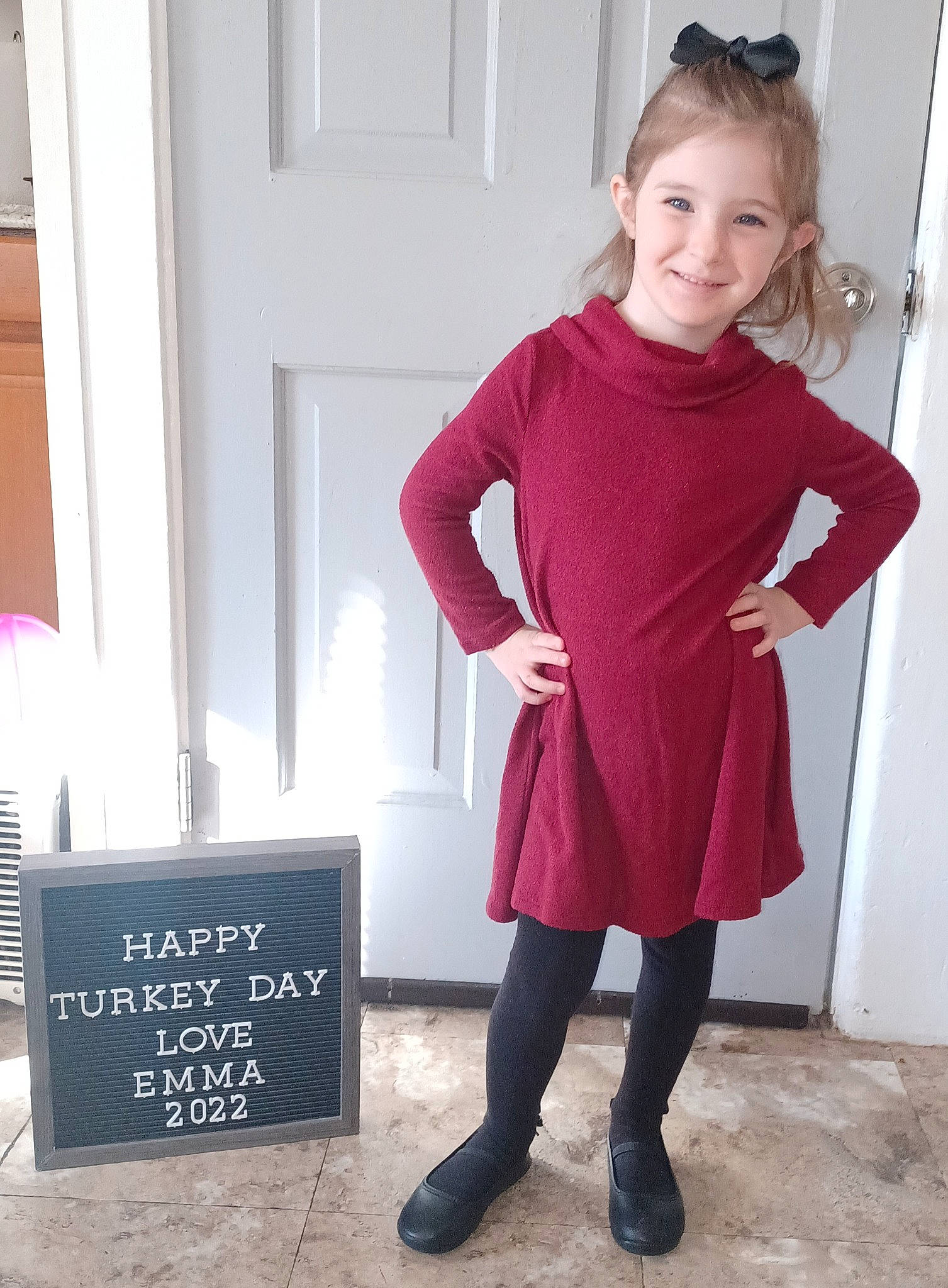 Emma is registered to the contest to win money with this photo: door, dress, electric_blue, fashion_accessory, fashion_design, flooring, footwear, formal_wear, handwriting, human_leg, joy, knee, magenta, pattern, person, shoe, sleeve, smile, standing, thigh