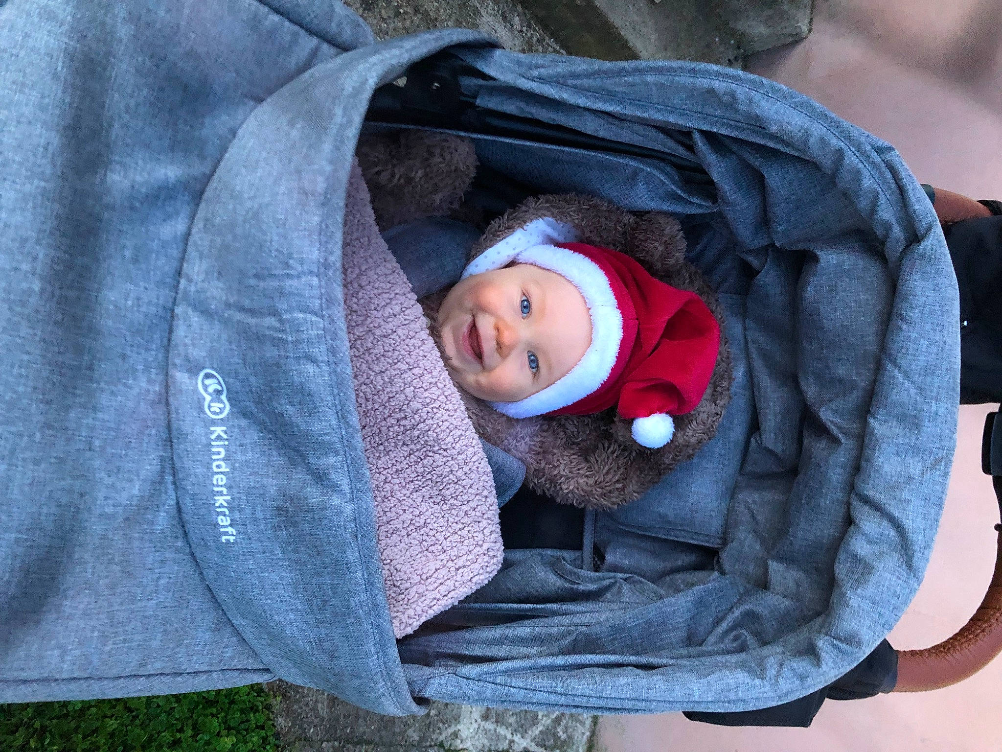 Tyméo participe au concours pour gagner de l'argent avec cette photo : baby, baby_carriage, baby_products, baby_toddler_clothing, cheek, child, comfort, electric_blue, grass, headgear, headwear, hood, jacket, outerwear, person, product, sitting, sleeve, smile, textile