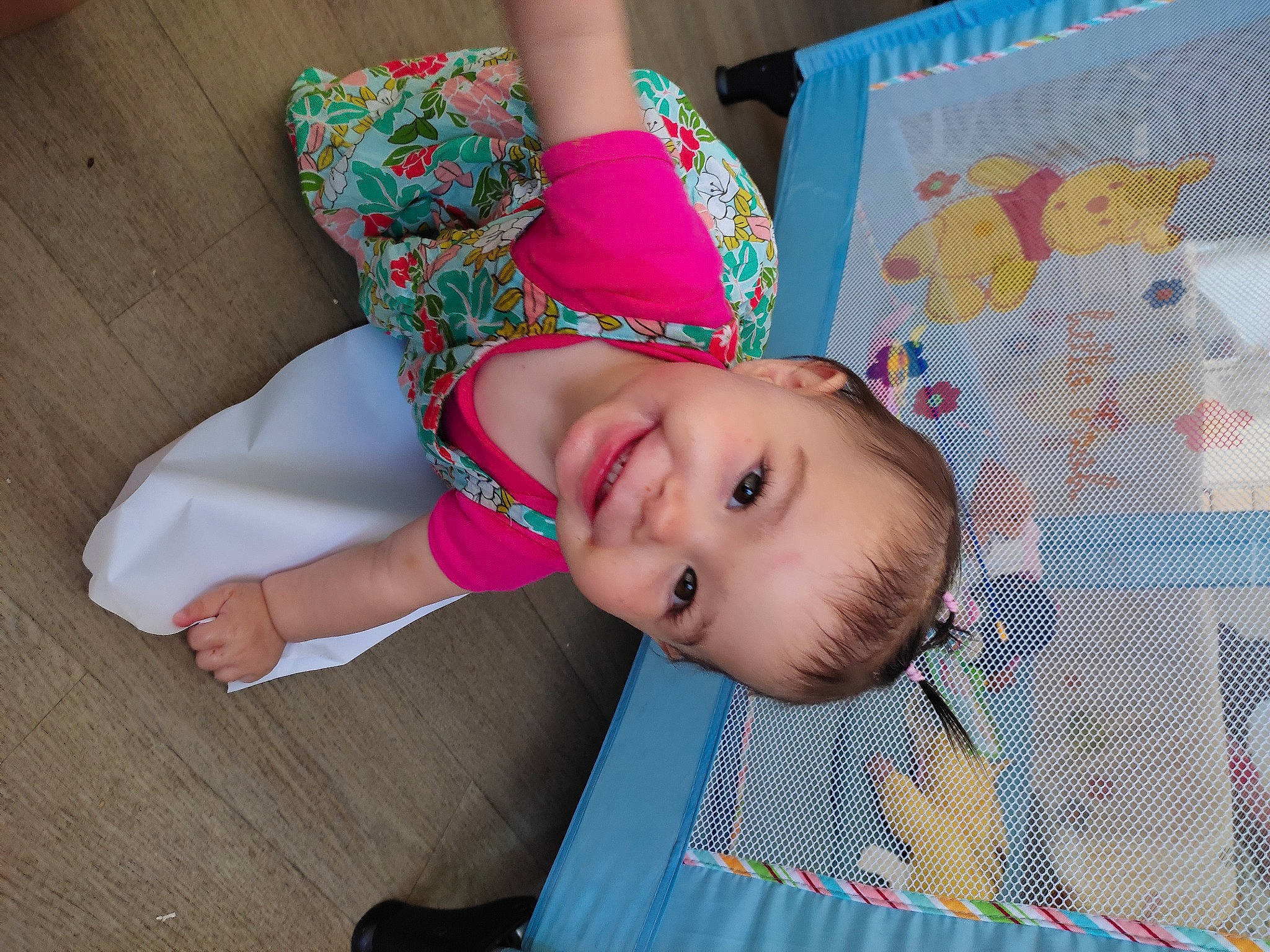 Lola participe au concours pour gagner de l'argent avec cette photo : baby, baby_products, baby_toddler_clothing, cheek, child, facial_expression, fashion_accessory, flooring, fun, happy, hardwood, human_leg, joy, linens, magenta, pattern, person, skin, sleeve, smile