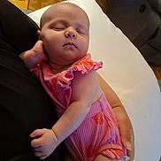 Maddie is registered to the contest to win money with this photo: baby, sleeping, infant, pink_clothing, person, arm, hand, indoor, couch, blanket, floor, carpet, relaxation, cute, portrait, child, face, peaceful, rest, home