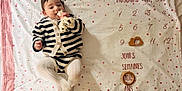 Iris a rejoint le concours — aidez-le/la à gagner de superbes lots ! age_milestone, baby, blanket, chewing, child, cute, french_text, giraffe, happy, indoors, infant, lying_down, portrait, smiling, soft_lighting, star_pattern, striped_clothing, tights, toy, wooden_markers