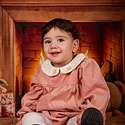 Iris a rejoint le concours — aidez-le/la à gagner de superbes lots ! black_shoes, blanket, child, cozy, cute, decorations, festive, fireplace, gifts, happy, holiday, indoor, pink_dress, portrait, seated, smiling, toddler, warm_lighting, white_tights, young_child