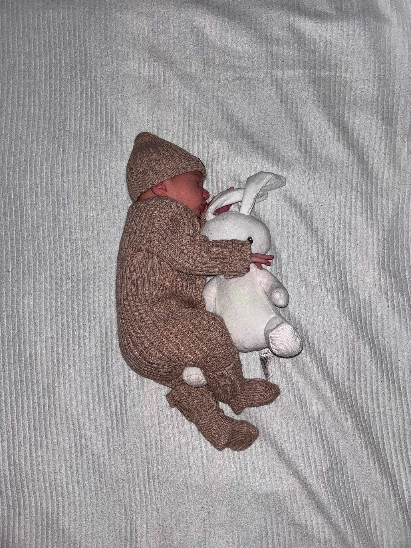 Marceau participe au concours pour gagner de l'argent avec cette photo : newborn, baby, sleeping, knitted_outfit, hat, stuffed_animal, bunny, blanket, cozy, soft, cuddly, infant, child, cute, resting, indoors, portrait, peaceful, toddler, warm