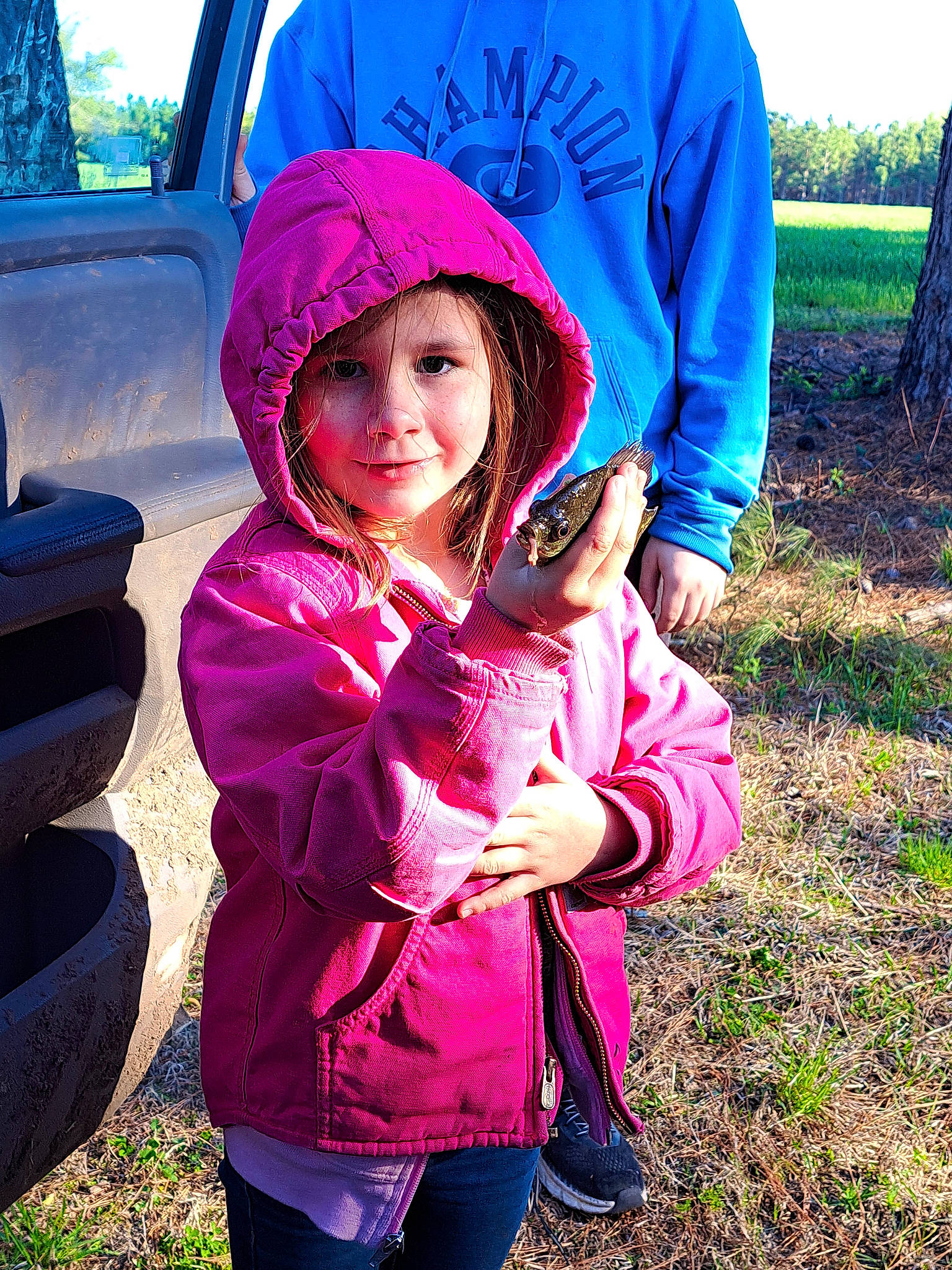 Ashlynn joined the competition — help win amazing prizes! blue, cap, cool, electric_blue, fun, grass, happy, headwear, leaf, leisure, magenta, morning, outerwear, people_in_nature, person, pink, recreation, tints_and_shades, toddler, vehicle_door