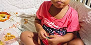 Amora is registered to the contest to win money with this photo: toddler, baby, child, crib, blanket, snack, container, pink_shirt, hair_beads, pigtails, lion_pattern, bedroom, indoor, sitting, curious, cute, face, hands, feet, expression