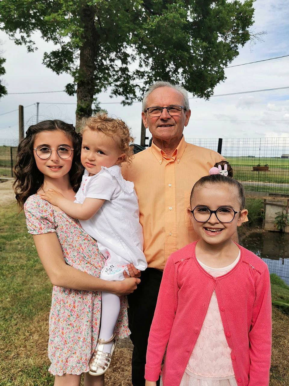 Louisa participe au concours pour gagner de l'argent avec cette photo : event, face, family_taking_photos_together, formal_wear, fun, gesture, grass, happy, interaction, iris, joy, leisure, people, people_in_nature, person, pink, plant, skin, sky, smile