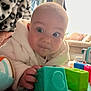 Osi joined the competition — help win amazing prizes! baby, child, toy, blocks, indoor, person, furniture, blanket, hand, face, couch, pillow, play, cute, infant, colorful, soft, clothing, living_room, curious