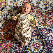 Osi joined the competition — help win amazing prizes! baby, infant, child, romper, patterned_clothing, carpet, colorful, texture, indoor, portrait, smiling, cute, face, hands, feet, lying_down, bright, happy, small, person