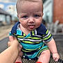 Arlen-Ray is registered to the contest to win money with this photo: baby, blue, blurred_background, child, cute, expression, face, green, hand, head, infant, mesh, outdoor, person, red_socks, sitting, skin, striped_clothing, table, tongue