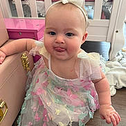 Isla joined the competition — help win amazing prizes! baby, butterfly, chest, child, crawling, crib, cute, dress, floor, furniture, headband, indoors, infant, pastel_colors, person, pink, playful, tongue, tulle, wooden_floor