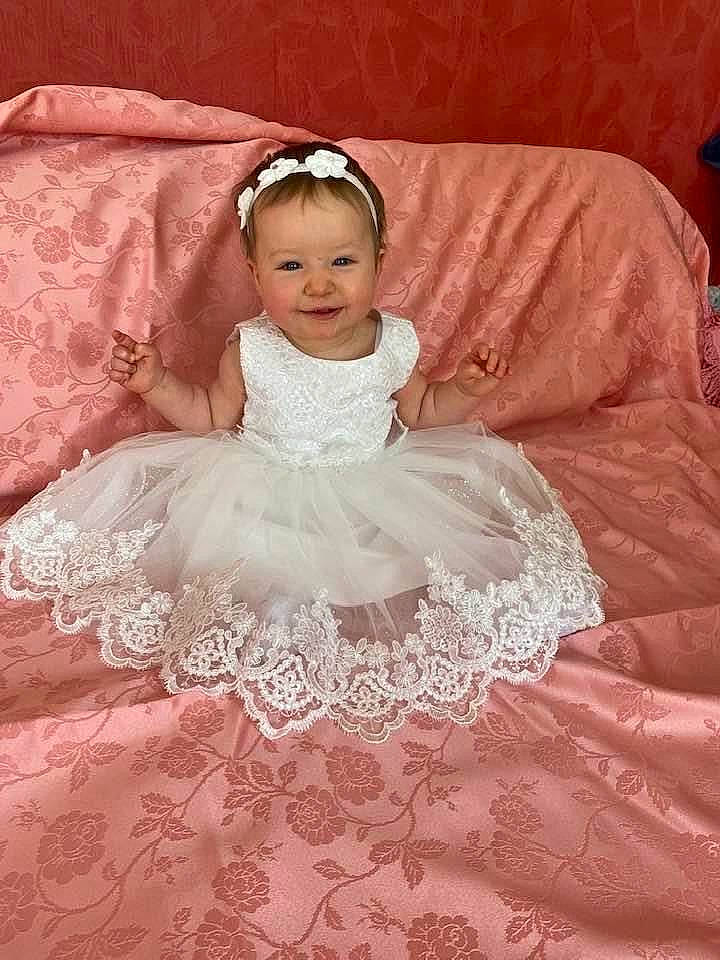 Léna a rejoint le concours — aidez-le/la à gagner de superbes lots ! baby, baby_toddler_clothing, bridal_clothing, dress, embellishment, eye, eyebrow, flash_photography, flooring, gown, happy, head, headpiece, iris, joy, person, pink, skin, sleeve, smile