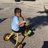 Waylon joined the competition — help win amazing prizes! child, boy, tricycle, playground, slide, outdoor, smiling, sunlight, pavement, shadow, play, recreation, fence, car, shoe, shorts, tshirt, fun, happy, park