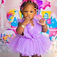 Emerald is registered to the contest to win money with this photo: toddler, child, dress, purple, bow, beads, bracelet, portrait, indoors, candy_theme, colorful, cute, fashion, baby, person, background, studio, smile, standing, jewelry