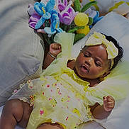 Zahara joined the competition — help win amazing prizes! arm_bracelet, baby, child, closeup, colorful, curly_hair, cushion, cute, headband, infant, knitted_flowers, outdoor, playful, plush_toy, portrait, relaxed, smiling, soft_fabric, sunlight, yellow_dress