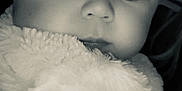 Weslynne joined the competition — help win amazing prizes! baby, infant, face, close_up, black_and_white, blanket, soft_texture, eyes, portrait, child, cute, warm, cozy, young, newborn, expression, indoor, person, head, fluffy
