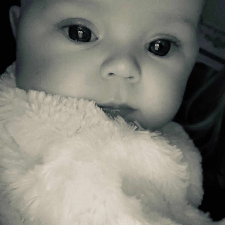 Weslynne joined the competition — help win amazing prizes! baby, black_and_white, blanket, child, close_up, cozy, cute, expression, eyes, face, fluffy, head, indoor, infant, newborn, person, portrait, soft_texture, warm, young