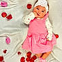 Soulana joined the competition — help win amazing prizes! adorable, baby, child, cute, decorations, flower, hand_in_mouth, headband, heart_pattern, indoors, infant, lying_down, person, pink_dress, portrait, rose_petals, socks, soft_texture, white_blanket, young_child