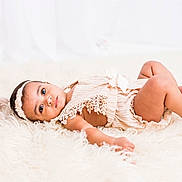 Delilah is registered to the contest to win money with this photo: baby, infant, child, lying_down, fluffy_rug, cream_outfit, headband, lace, soft_toys, pastel_colors, cute, portrait, indoor, looking_at_camera, small_feet, peaceful, adorable, young_child, soft_lighting, cozy