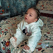 Daisy-Mae joined the competition — help win amazing prizes! toddler, child, bed, blanket, hoodie, socks, person, indoor, floral_pattern, toy, wallpaper, curious, seated, cute, cozy, portrait, home, soft_lighting, clothing, hairclip