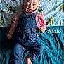 baby, denim_overalls, pink_shirt, smiling, lying_down, blanket, sea_turtles, cute, child, infant, happy, blue_eyes, bare_feet, fabric, pattern, playful, portrait, indoors, clothing, colorful