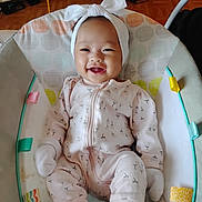 Aaliyah joined the competition — help win amazing prizes! baby, child, infant, smiling, happy, portrait, headband, bow, onesie, clothing, bouncer, baby_seat, toy, indoor, home, floor, furniture, face, sitting, closeup