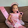 Aaliyah joined the competition — help win amazing prizes! child, toddler, birthday, birthday_crown, birthday_sash, sunglasses, pink, dress, smiling, sitting, couch, indoors, party, celebration, sparkles, headband, toy, portrait, happy, photography