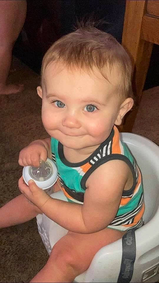 Tripp is registered to the contest to win money with this photo: arm, baby, baby_toddler_clothing, cheek, chin, drinkware, ear, eye, eyebrow, eyelash, facial_expression, finger, hand, head, iris, joint, joy, mouth, neck, nose