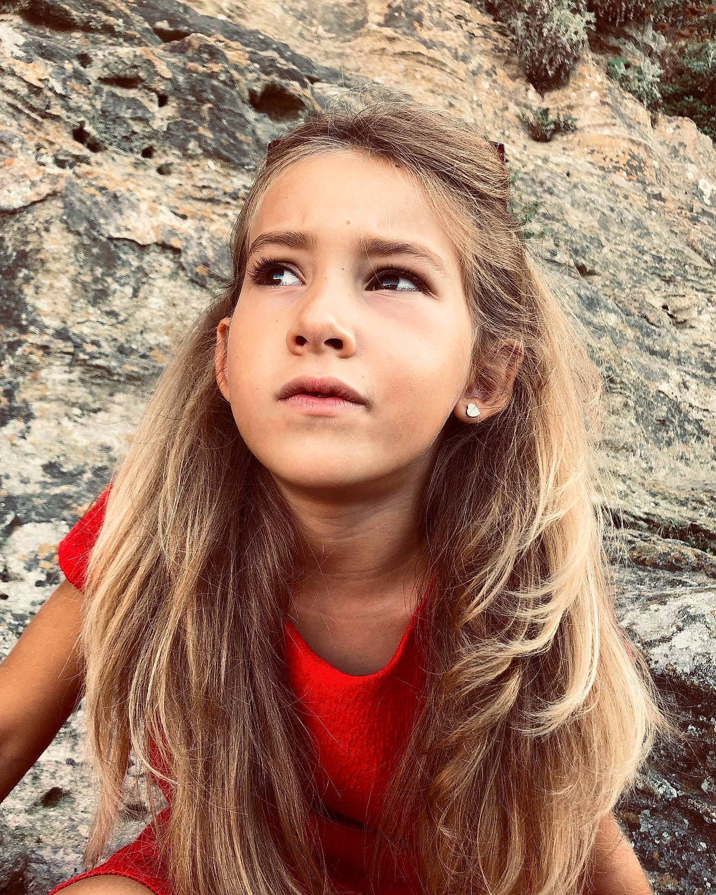 Oriane participe au concours pour gagner de l'argent avec cette photo : blond, brown_hair, chin, facial_expression, flash_photography, fun, grass, happy, leisure, lip, long_hair, neck, people_in_nature, person, red, rock, sitting, skin, soil, tree