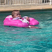 Alma a rejoint le concours — aidez-le/la à gagner de superbes lots ! baby, inflatable_ring, pool, water, child, floating, pink, swimming_pool, outdoor, summer, relaxing, fence, baby_clothing, infant, sunlight, sitting, peaceful, young_child, water_surface, recreation